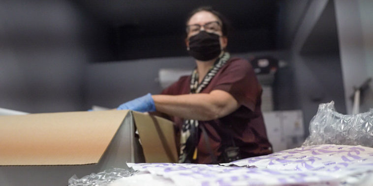 妇女打开新冠病毒-19疫苗包装；疫苗犹豫不决已成为一个现实问题